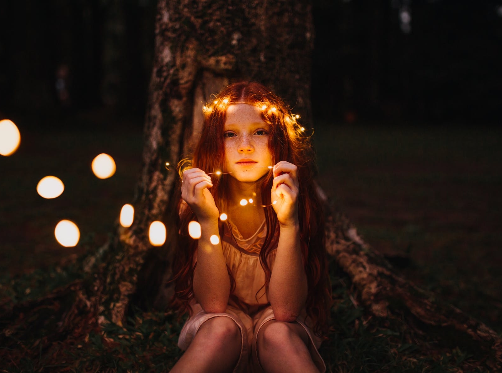 girl holding string lights
